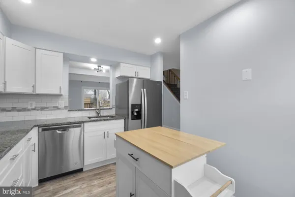 a kitchen with refrigerator and cabinets