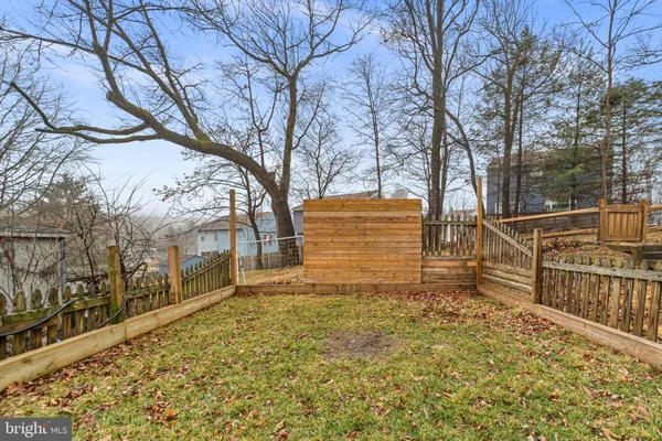 a view of a yard with wooden fence