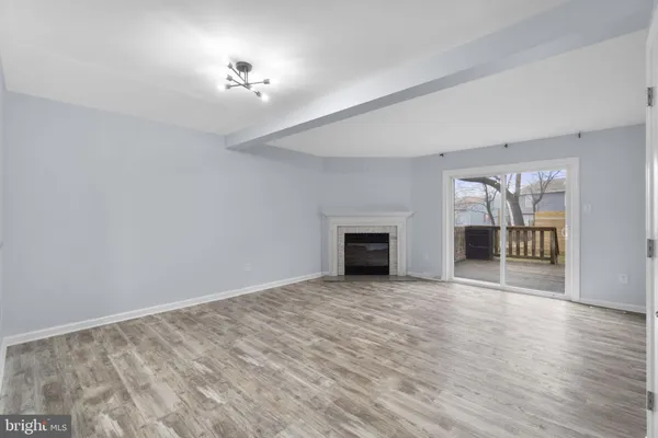 a view of an empty room with a fireplace and a window