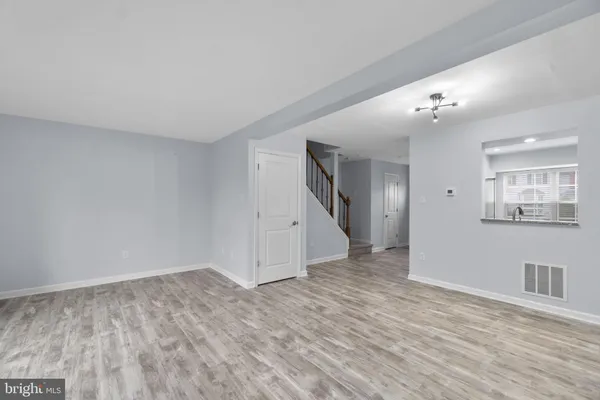 a view of empty room with wooden floor and ceiling fan