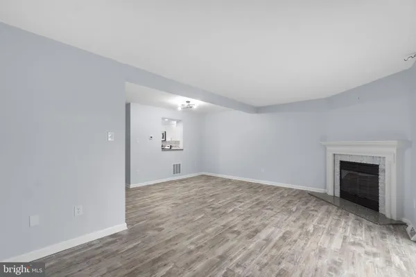 a view of empty room with wooden floor and fireplace