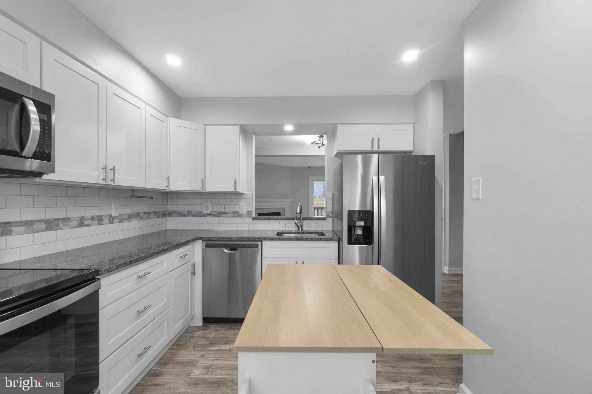 930 Gaming Square Hampstead, MD 21074 - Photo 10 of 36 a kitchen with kitchen island a sink stainless steel appliances and cabinets