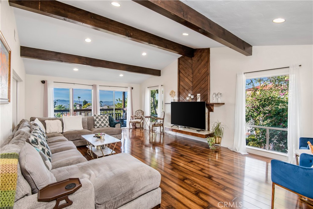 a living room with furniture flat screen tv and a large window