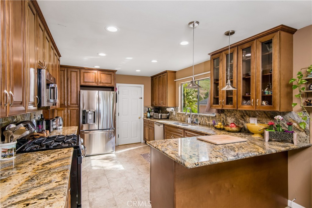 1036 Sherlock Drive Burbank, CA 91501 - Photo 8 of 28 a kitchen with stainless steel appliances granite countertop a sink stove and refrigerator