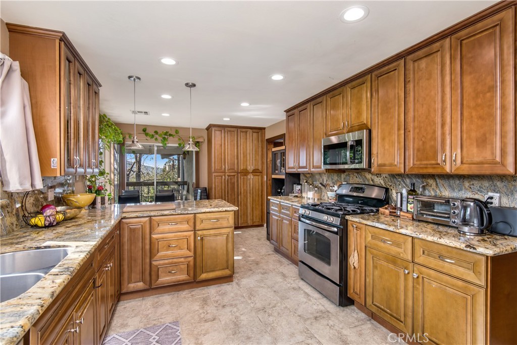 1036 Sherlock Drive Burbank, CA 91501 - Photo 9 of 28 a large kitchen with stainless steel appliances granite countertop a stove a sink and a microwave