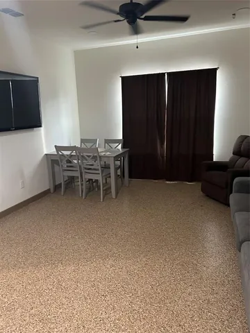a view of an empty room with furniture and a window
