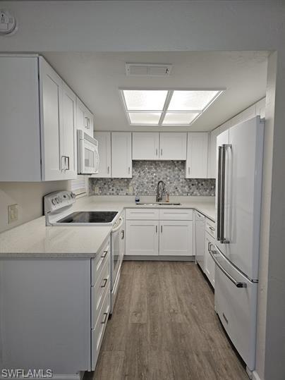 3005 Gordon Street Naples, FL 34112 - Photo 4 of 11 Kitchen with white cabinets, white appliances, dark wood finished floors, and light stone countertops
