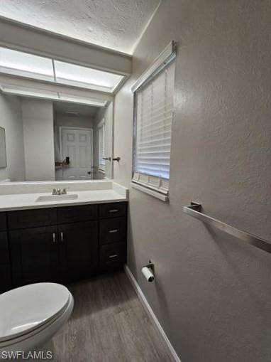 3005 Gordon Street Naples, FL 34112 - Photo 6 of 11 Half bathroom with vanity, dark wood finished floors, a textured ceiling, and a textured wall