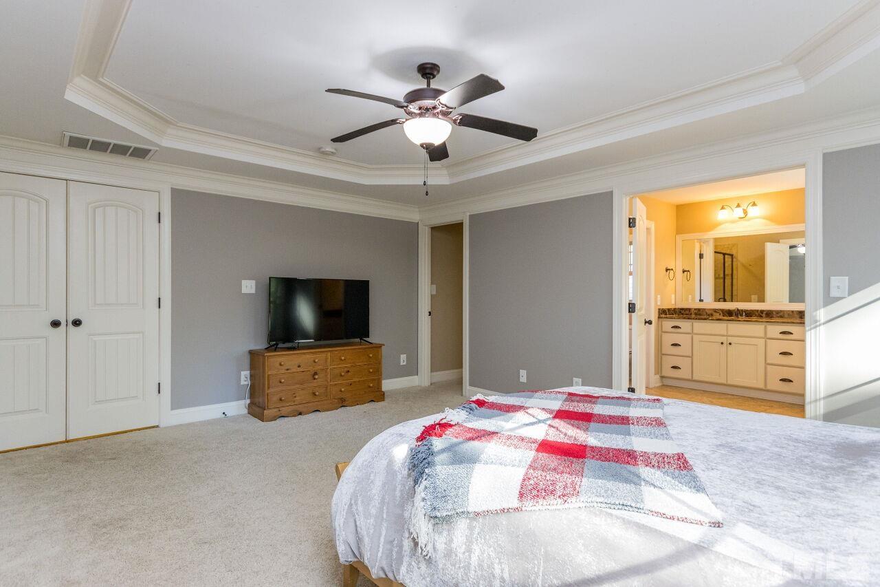 1340 Trinity Road Cary, NC 27513 - Photo 16 of 30 a bedroom with a bed and a flat screen tv