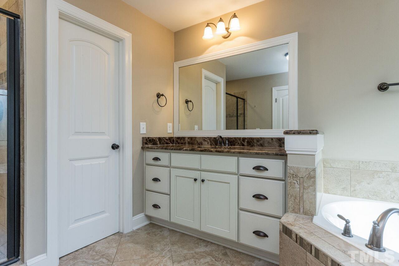 1340 Trinity Road Cary, NC 27513 - Photo 17 of 30 a bathroom with a granite countertop sink and a mirror