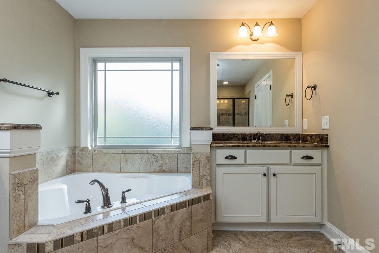 1340 Trinity Road Cary, NC 27513 - Photo 18 of 30 a bathroom with a bathtub a sink and a mirror