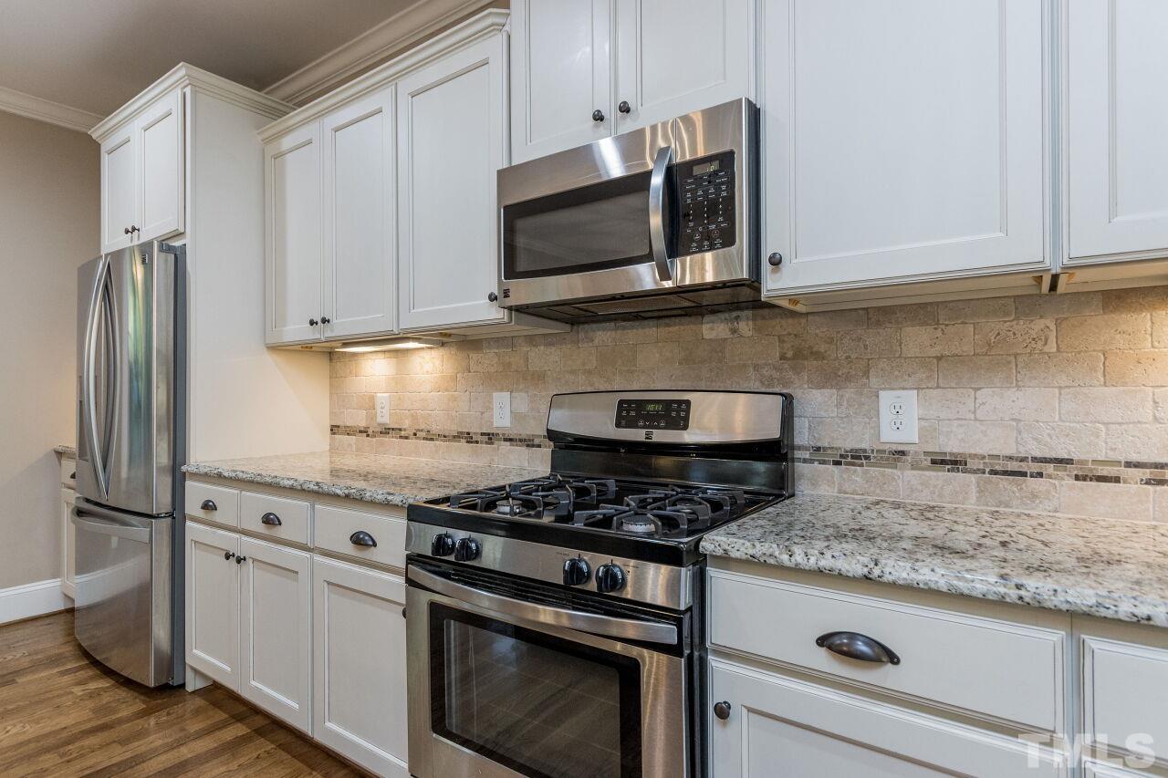 1340 Trinity Road Cary, NC 27513 - Photo 8 of 30 a kitchen with stainless steel appliances granite countertop a stove and a refrigerator