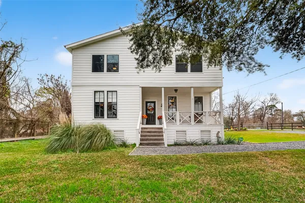 a front view of a house with swimming pool and porch with seating space