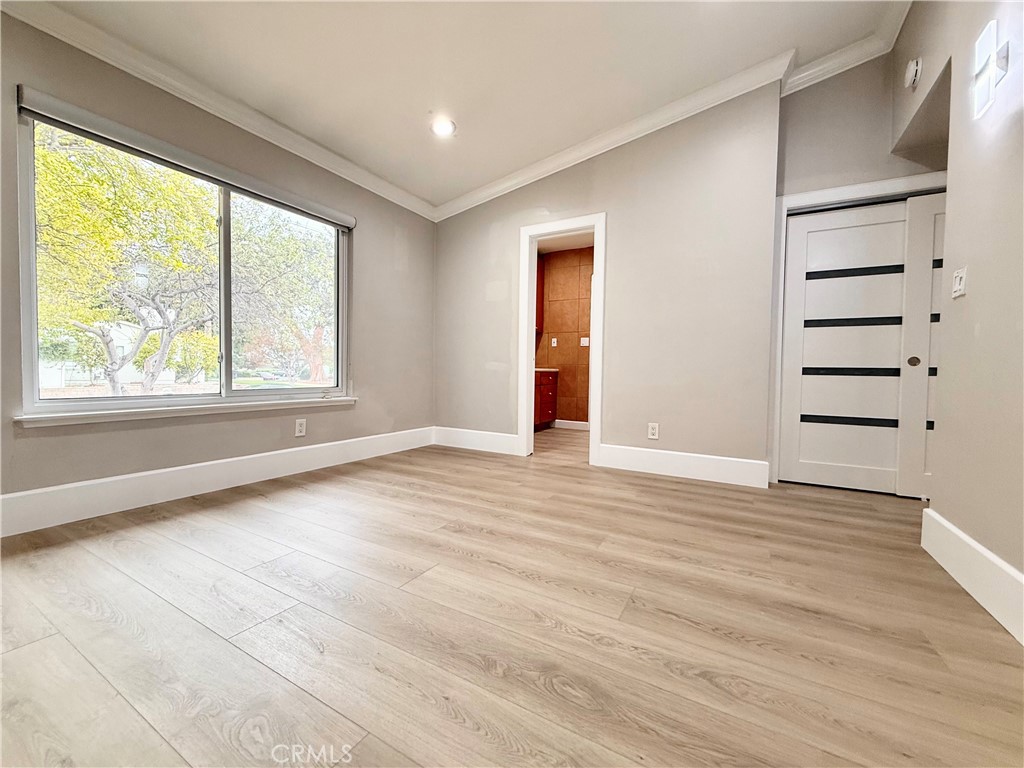 24204 Calvert Street Woodland Hills, CA 91367 - Photo 29 of 70 a view of an empty room with a window and wooden floor