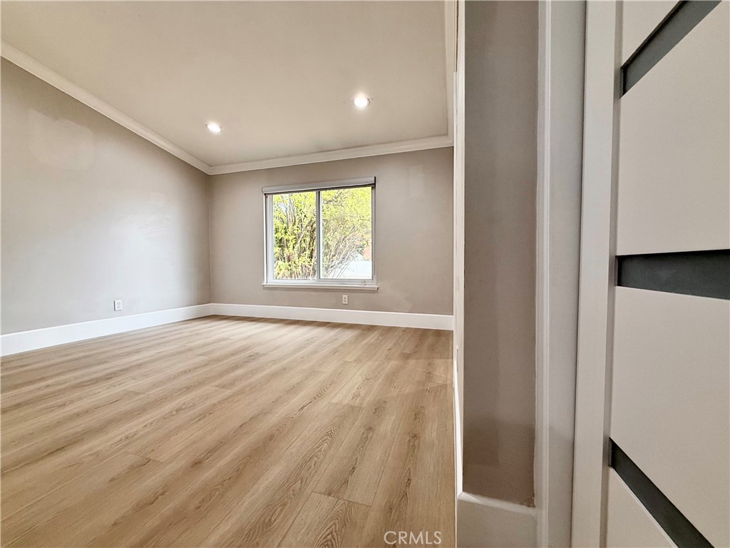 24204 Calvert Street Woodland Hills, CA 91367 - Photo 32 of 70 an empty room with wooden floor and windows