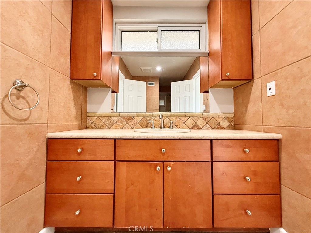 24204 Calvert Street Woodland Hills, CA 91367 - Photo 34 of 70 a bathroom with a sink and a mirror