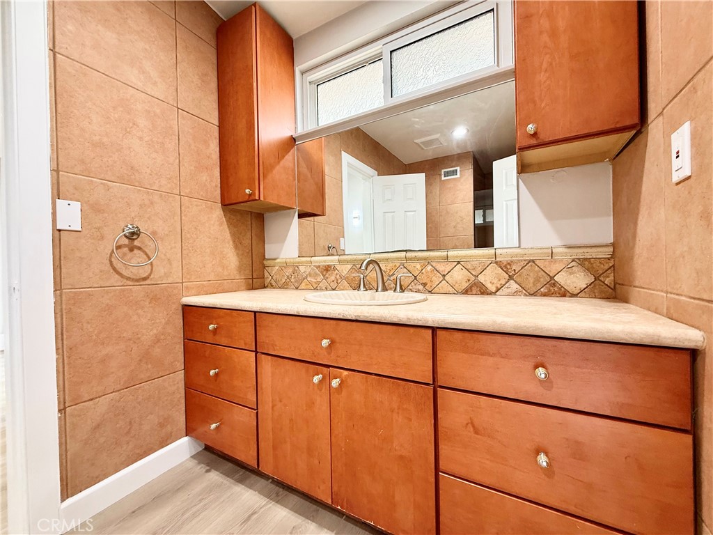 24204 Calvert Street Woodland Hills, CA 91367 - Photo 35 of 70 a bathroom with a sink and a mirror