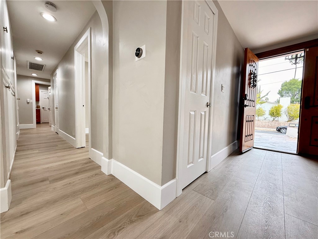 24204 Calvert Street Woodland Hills, CA 91367 - Photo 38 of 70 a view of a hallway with wooden floor and windows