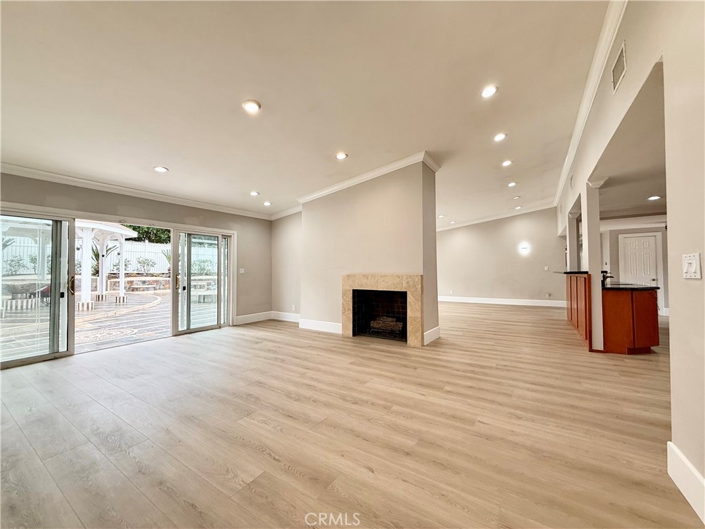 24204 Calvert Street Woodland Hills, CA 91367 - Photo 54 of 70 a view of an empty room with wooden floor and a kitchen