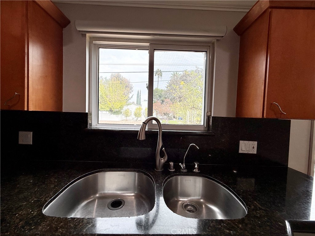 24204 Calvert Street Woodland Hills, CA 91367 - Photo 56 of 70 a kitchen with a sink a window and cabinets
