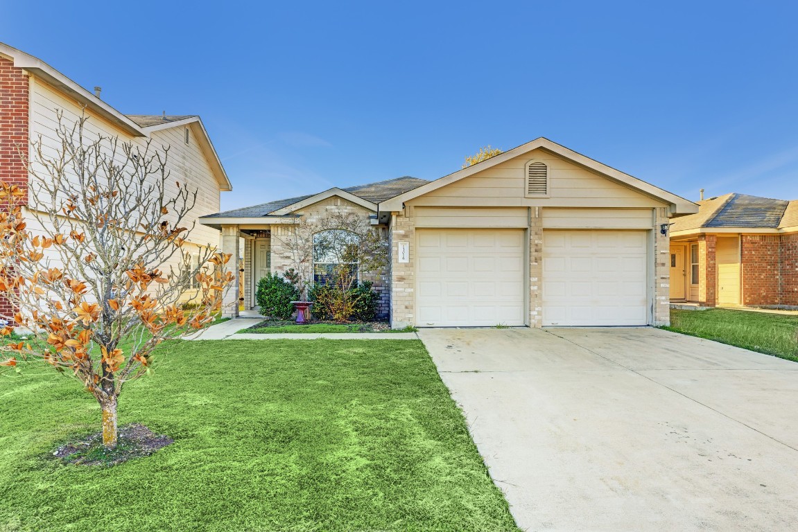 a front view of a house with a yard and garage