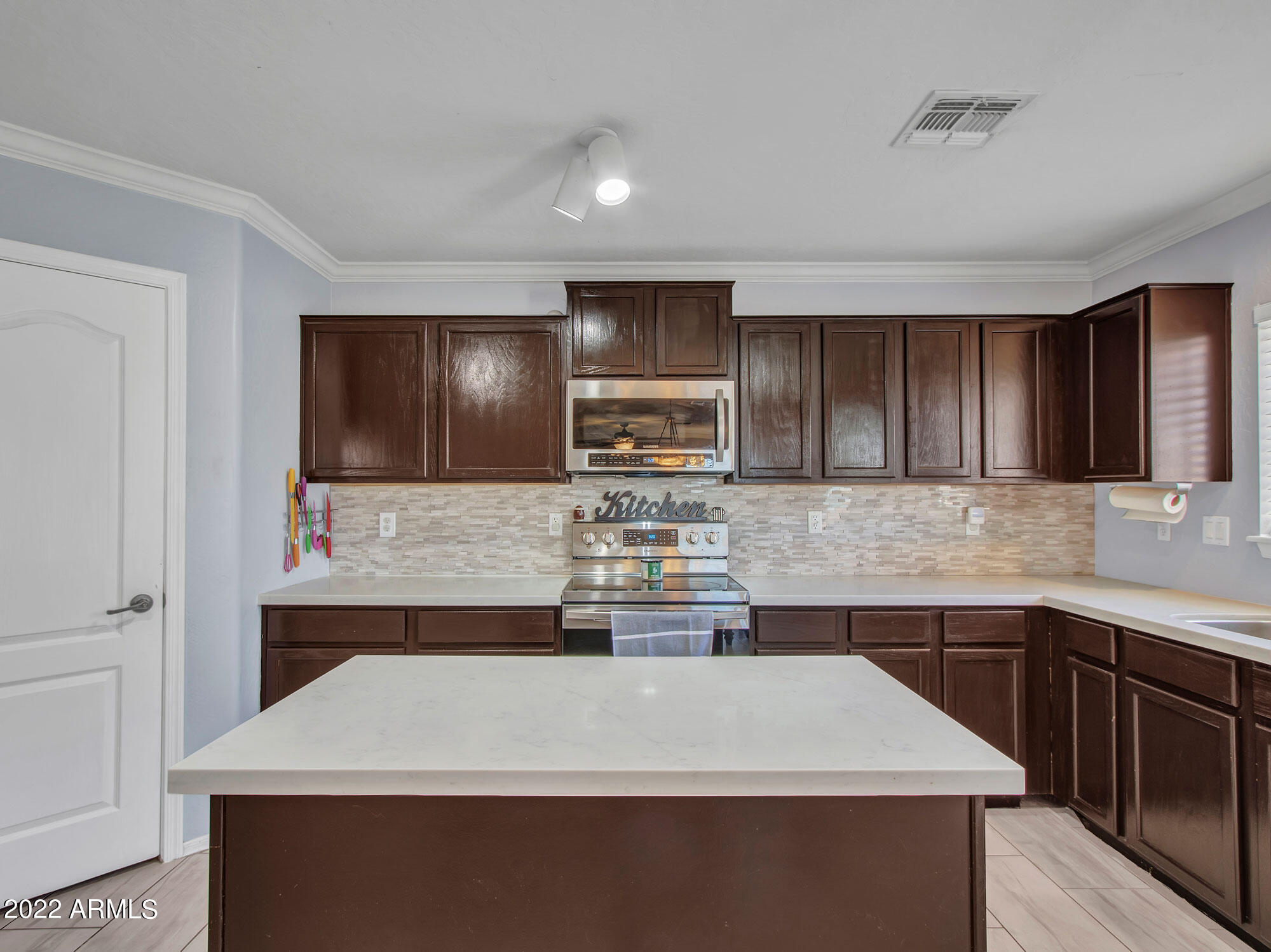 11645 West Mountain View Road Youngtown, AZ 85363 - Photo 14 of 45 a kitchen with kitchen island stainless steel appliances a sink stove and cabinets