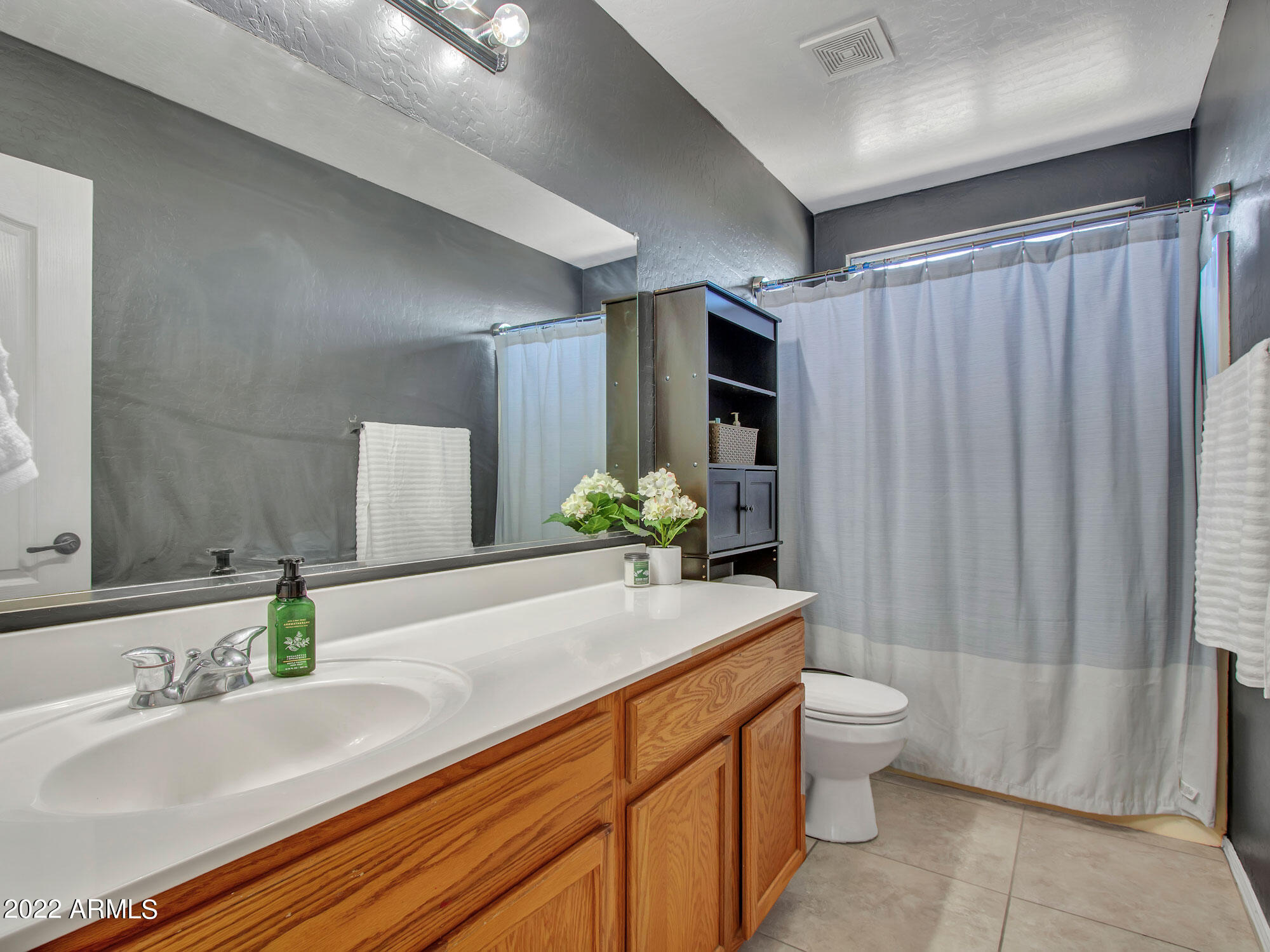 11645 West Mountain View Road Youngtown, AZ 85363 - Photo 29 of 45 a bathroom with a granite countertop sink and a mirror