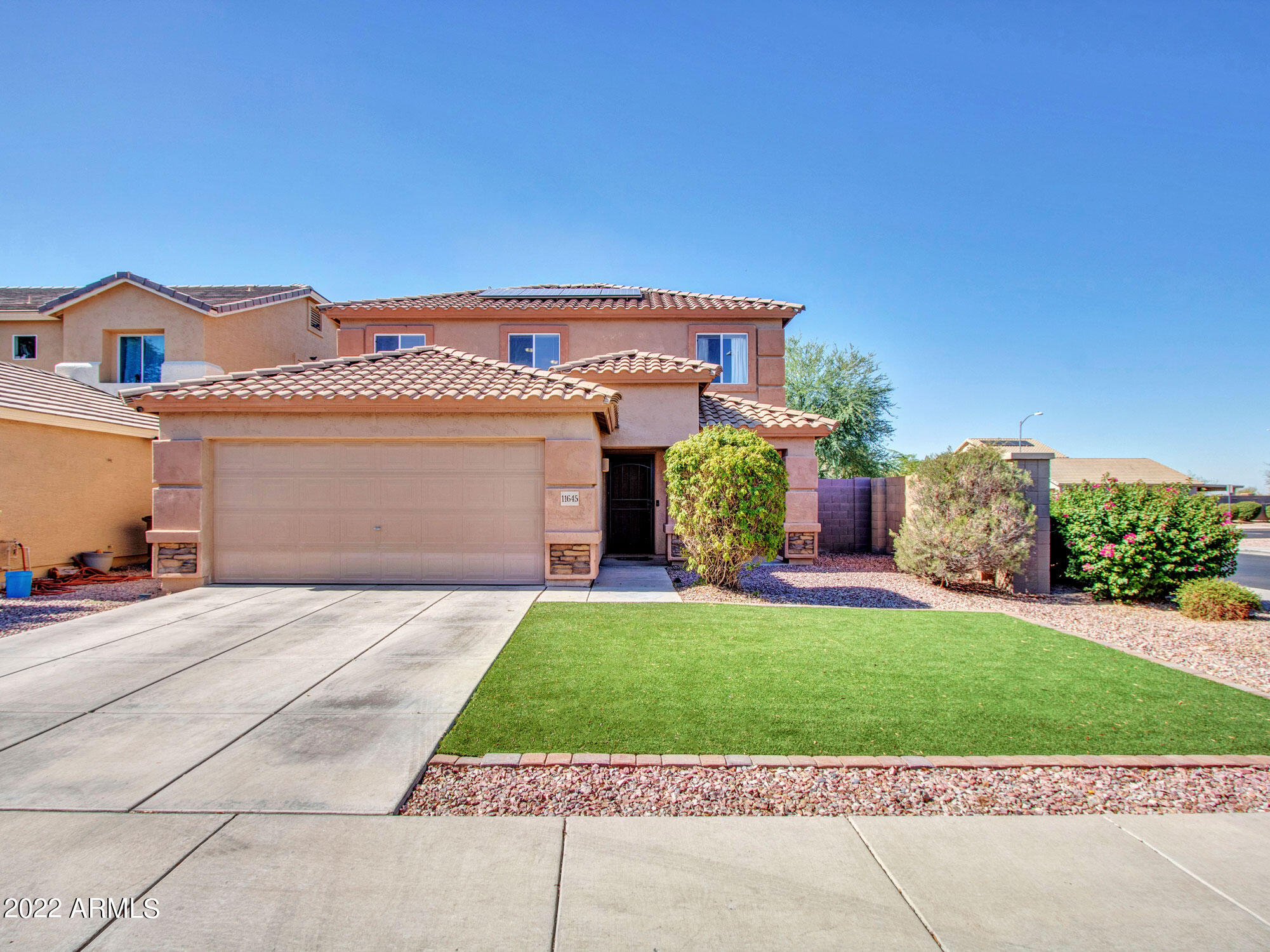11645 West Mountain View Road Youngtown, AZ 85363 - Photo 7 of 45 a front view of a house with a garden and plants