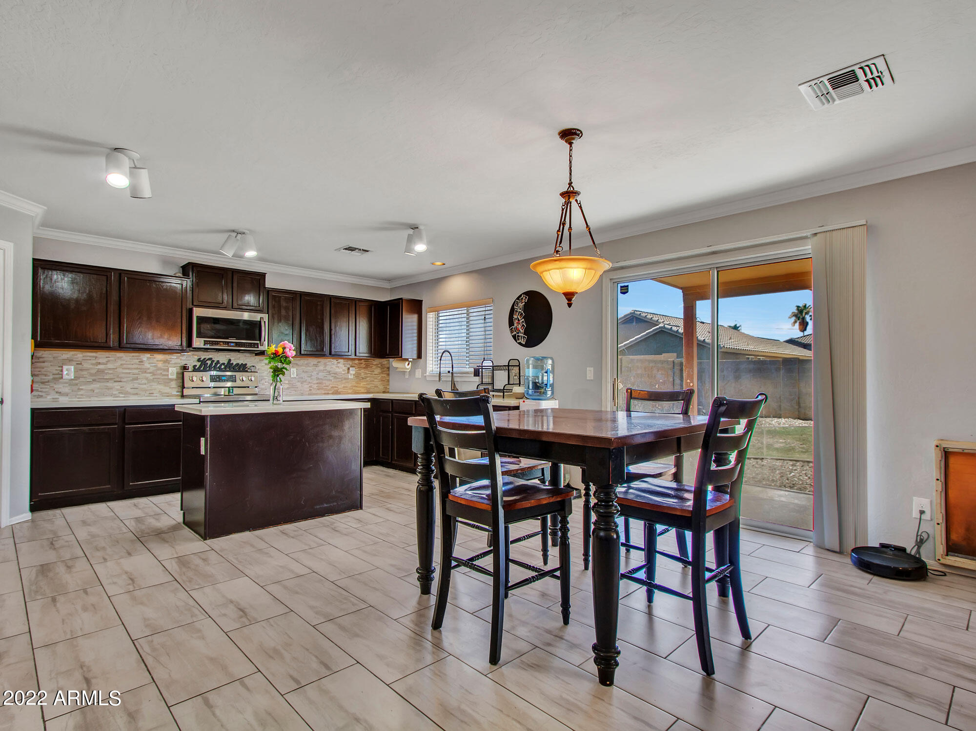 11645 West Mountain View Road Youngtown, AZ 85363 - Photo 10 of 45 a kitchen with stainless steel appliances kitchen island granite countertop a sink table and chairs