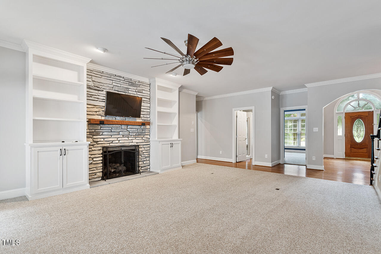 909 Rockfall Court Raleigh, NC 27614 - Photo 11 of 38 a view of a livingroom with a fireplace a sink and a chandelier fan