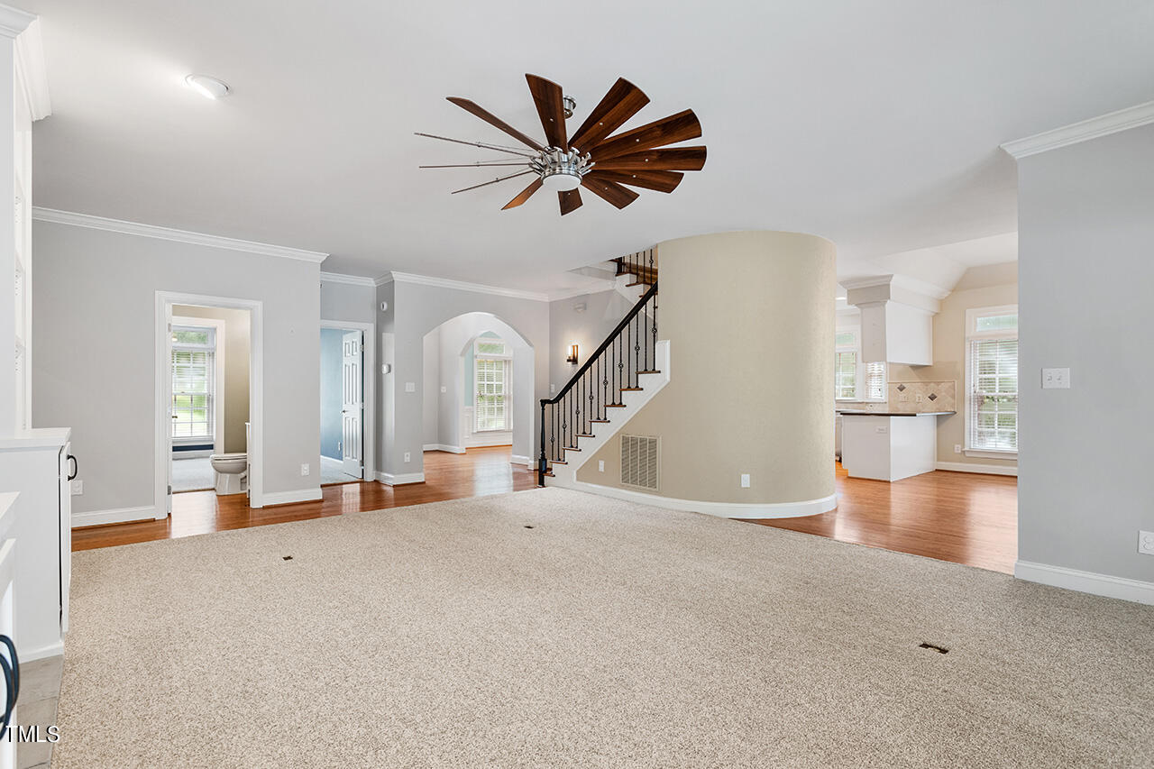 909 Rockfall Court Raleigh, NC 27614 - Photo 12 of 38 a view of a livingroom with a ceiling fan and wooden floor