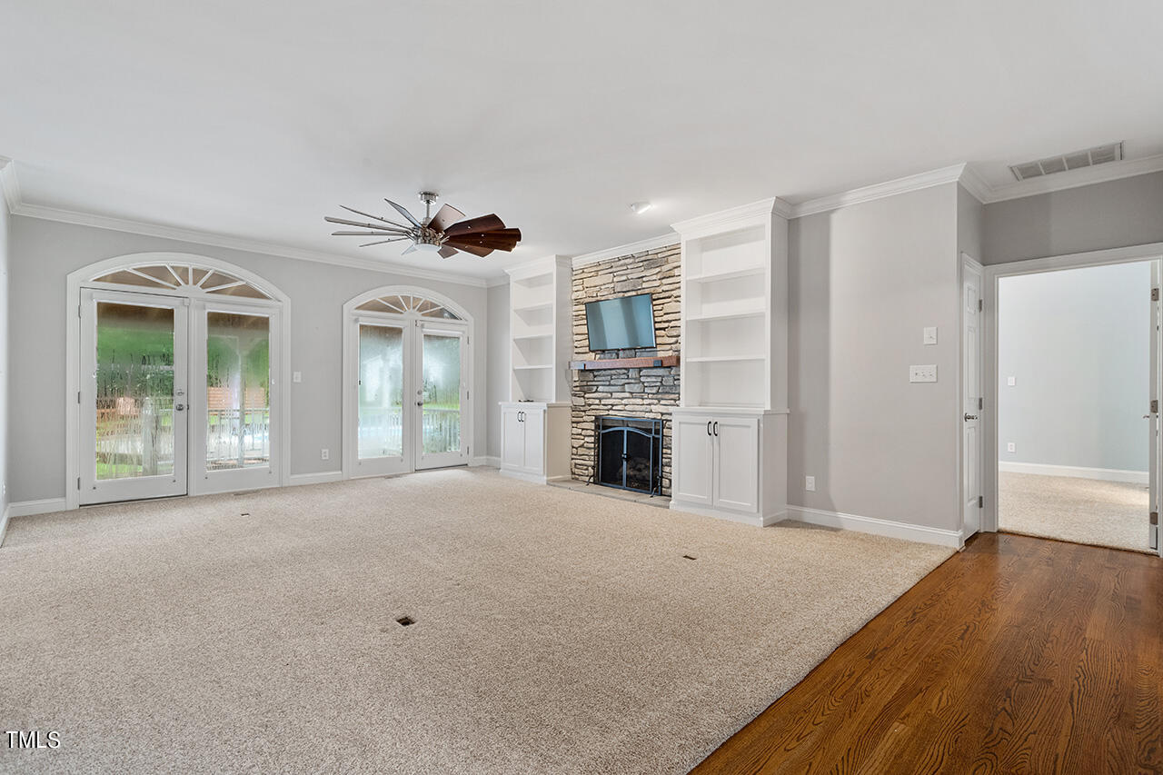 909 Rockfall Court Raleigh, NC 27614 - Photo 14 of 38 a view of an empty room with a fireplace and a window