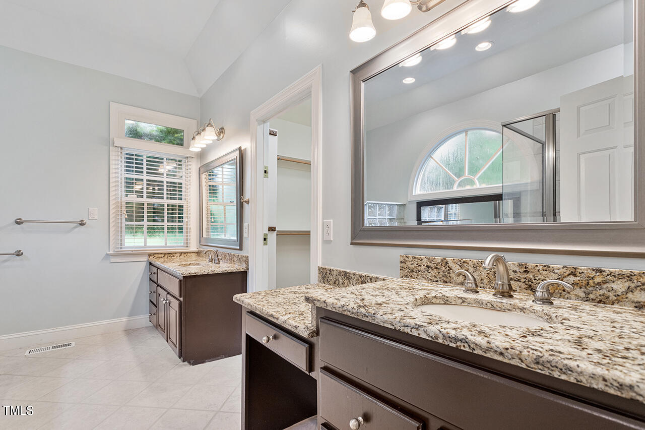 909 Rockfall Court Raleigh, NC 27614 - Photo 19 of 38 a bathroom with a granite countertop sink and a mirror