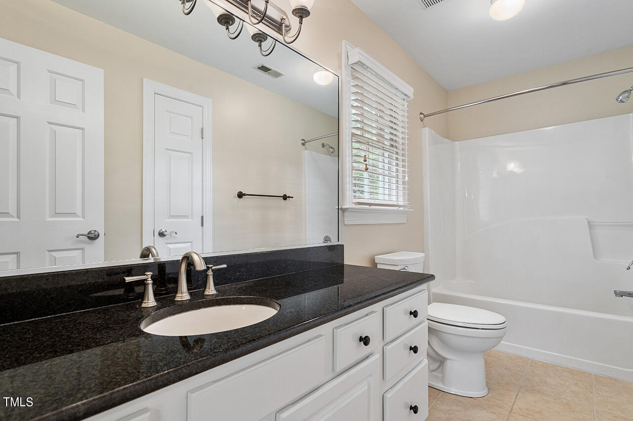 909 Rockfall Court Raleigh, NC 27614 - Photo 22 of 38 a bathroom with a granite countertop double vanity sink and a mirror