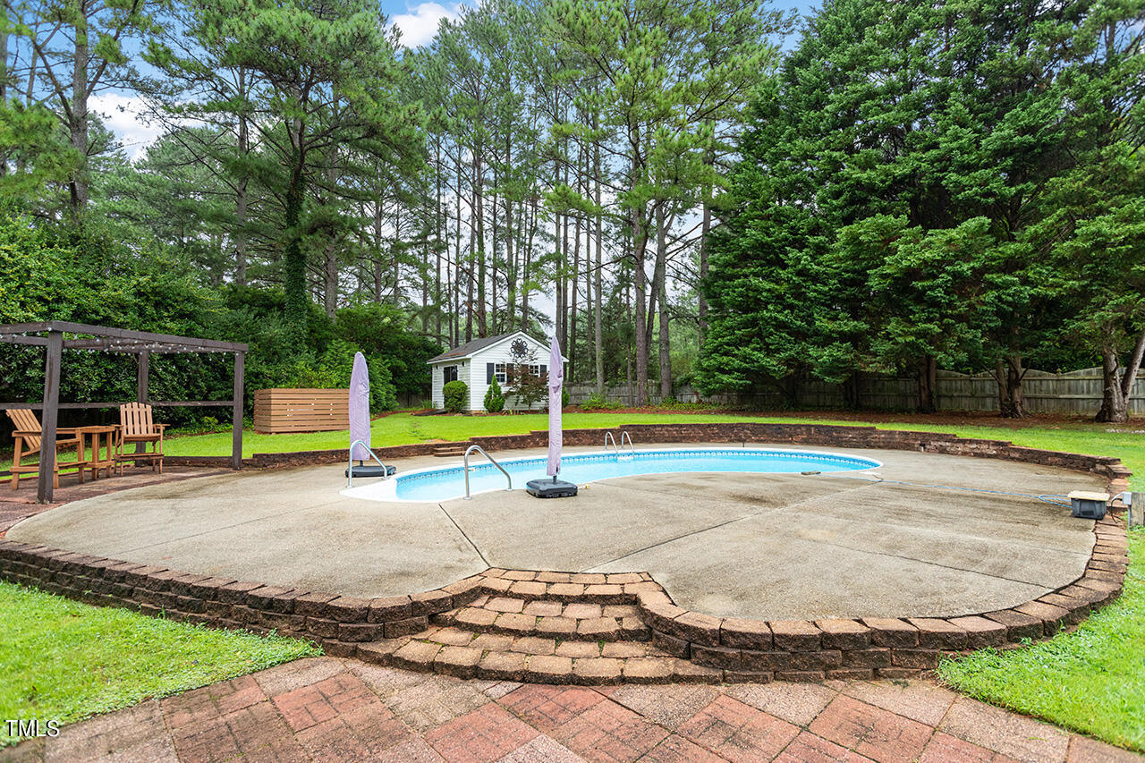 909 Rockfall Court Raleigh, NC 27614 - Photo 33 of 38 a view of a swimming pool with a yard and sitting area