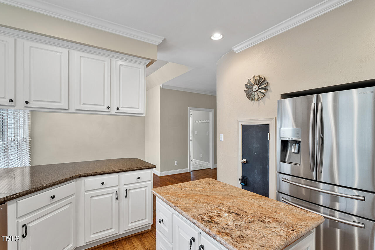 909 Rockfall Court Raleigh, NC 27614 - Photo 7 of 38 a kitchen with granite countertop a refrigerator and cabinets