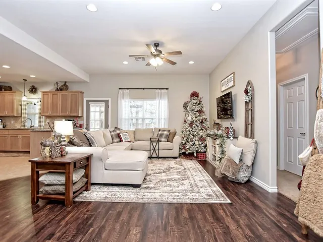a living room with furniture or chandelier and a wooden floor