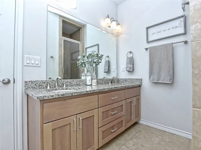 a bathroom with a granite countertop sink and a bathtub