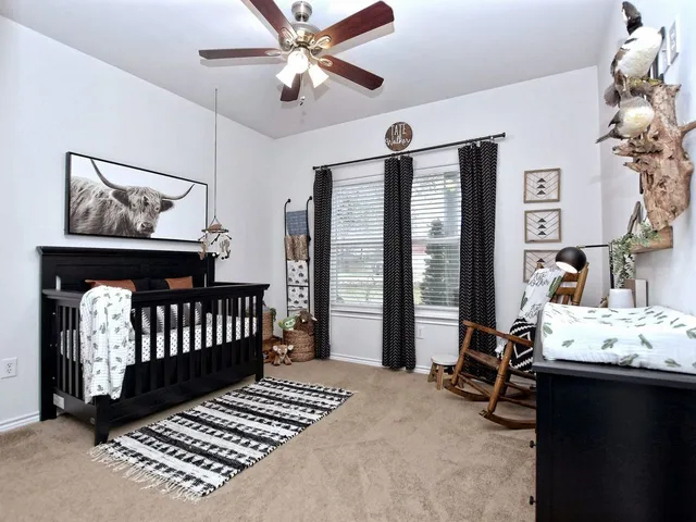 a bathroom with a granite countertop sink a toilet a mirror and shower curtain