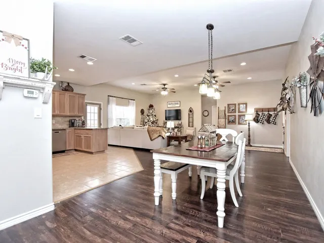 a view of a dining room and livingroom with furniture wooden floor a chandelier