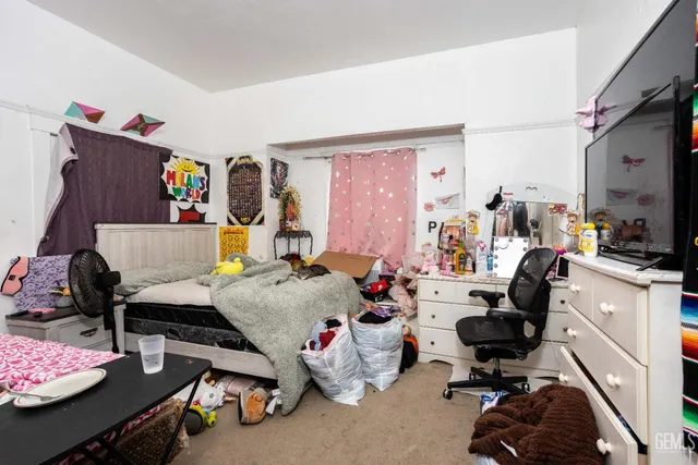a bedroom with furniture and a flat screen tv