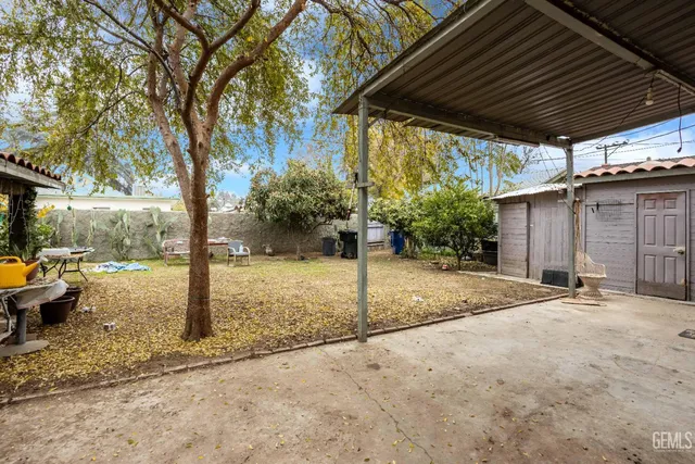 a view of a backyard with table and chairs under an umbrella