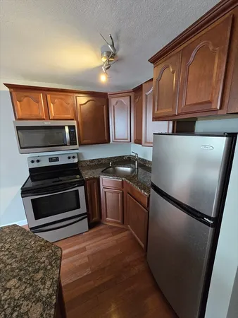 a kitchen with granite countertop a refrigerator stove and microwave