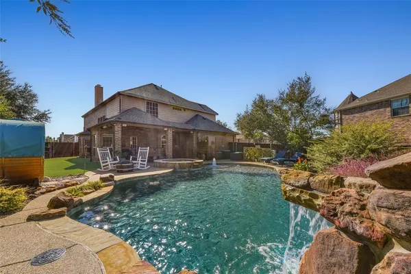 a view of a house with backyard sitting area and swimming pool