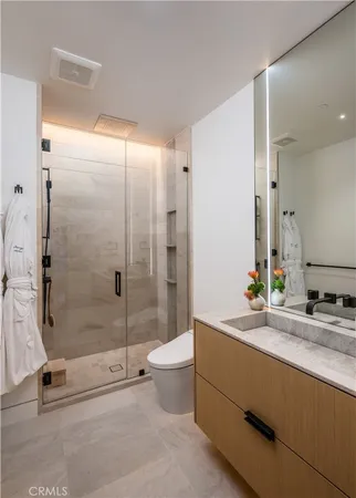 a bathroom with a granite countertop sink a toilet and shower