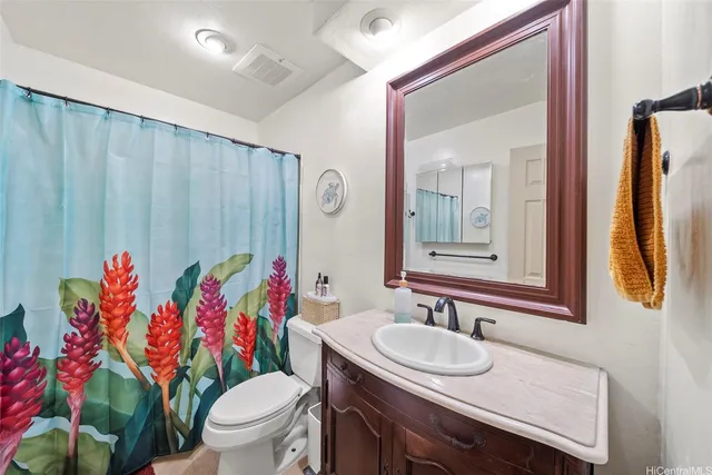 a bathroom with a sink vanity mirror and toilet