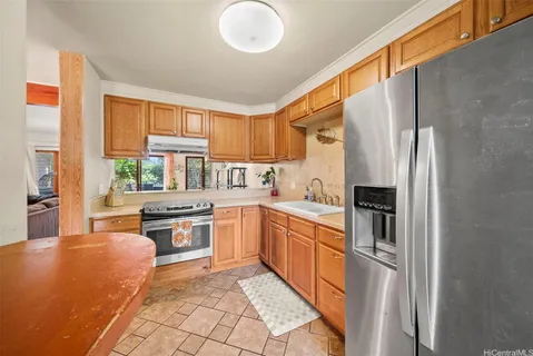 a kitchen with stainless steel appliances granite countertop a stove a sink and a refrigerator