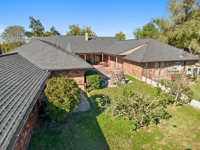 a aerial view of a house with a yard and potted plants