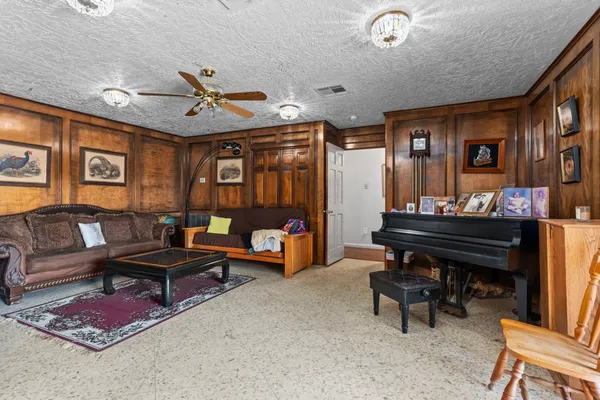 a living room with furniture a rug and a piano