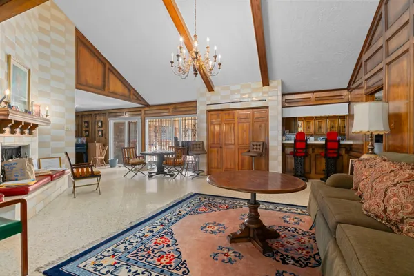 a living room with fireplace furniture and a large window